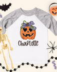Halloween-themed t-shirt with pumpkin design and skeleton, surrounded by Halloween decorations.