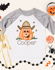 Halloween-themed shirt with a pumpkin wearing a cowboy hat and the name 'Cooper', surrounded by Halloween decorations.