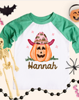 Halloween-themed shirt with a pumpkin and skeleton, surrounded by Halloween decorations.