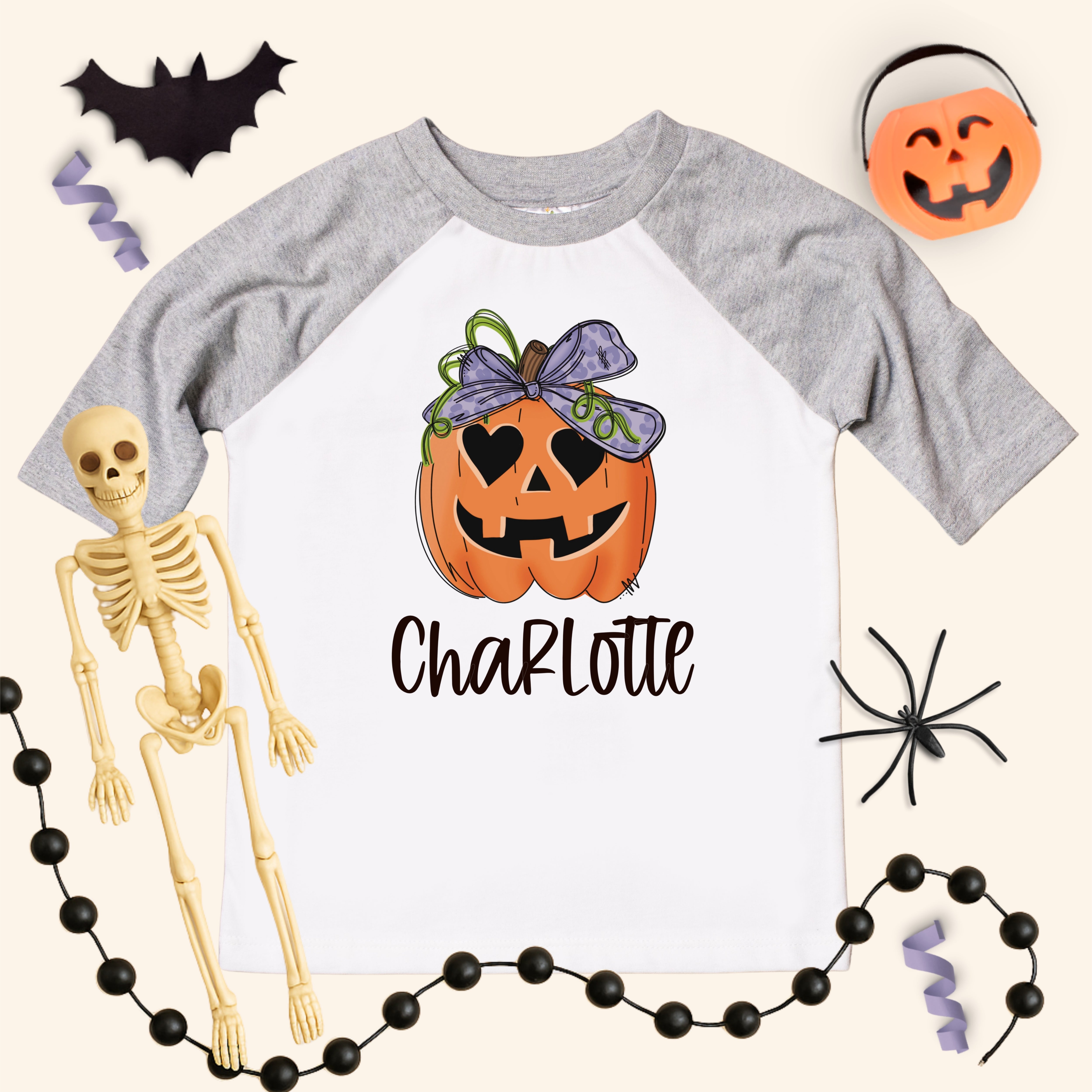 Halloween-themed t-shirt with pumpkin design and skeleton, surrounded by Halloween decorations.